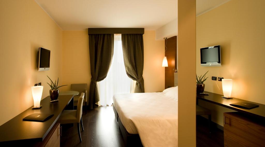 Postel nebo postele na pokoji v ubytování Red's Redaelli Hotel