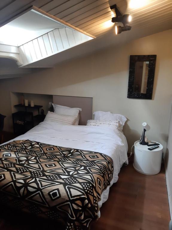 une chambre avec un grand lit avec des draps blancs dans l'établissement Maison de charme, à La Rochelle