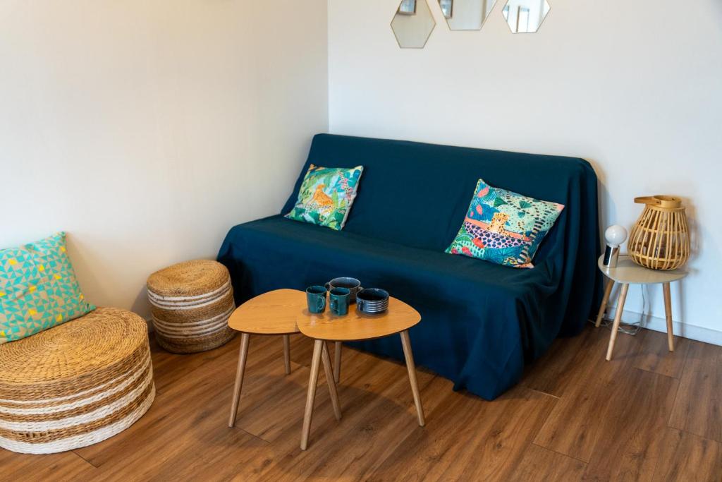 un salon avec un canapé bleu et une table dans l'établissement Bleu Bonheur, appartement cosy au coeur de la Baie, à Saint-Valery-sur-Somme