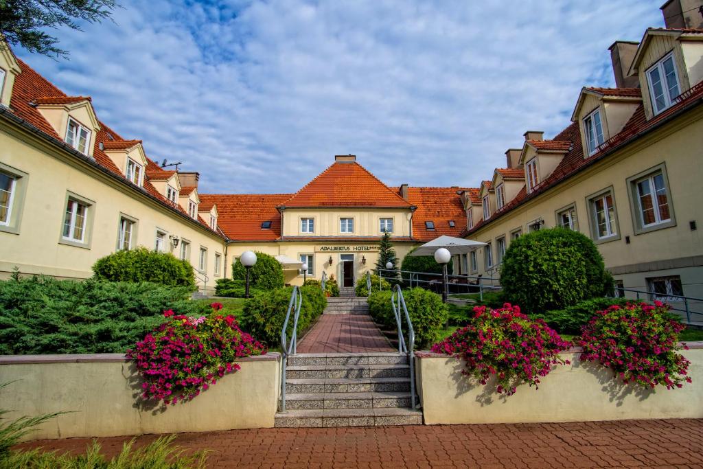 een groep gebouwen met trappen en bloemen bij Hotel Adalbertus in Gniezno