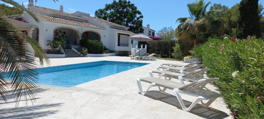 una villa con piscina e sedie a sdraio di Casa Belle a Jávea