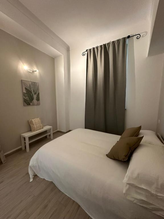 a bedroom with a large white bed with a curtain at L'Angolo Rosa in Casale Monferrato