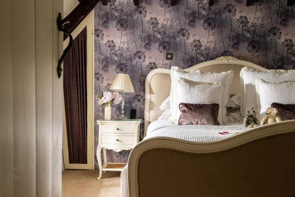 - une chambre avec un lit blanc et du papier peint violet dans l'établissement Rose Cottage, à High Bickington