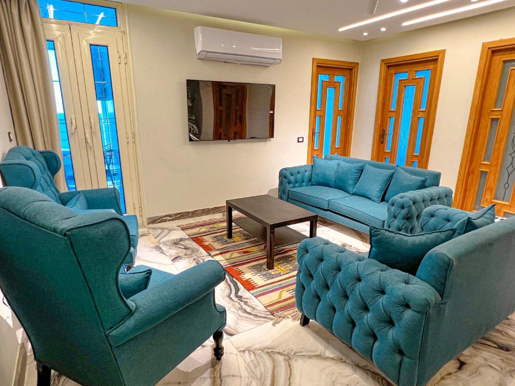 a living room with blue chairs and couches at Skyline Premium Properties in Alexandria