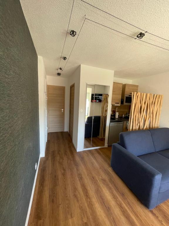 un salon avec un canapé bleu et une cuisine dans l'établissement Appartement plage du cap Rousset carry le rouet 1 chambre 6 couchages, à Carry-le-Rouet