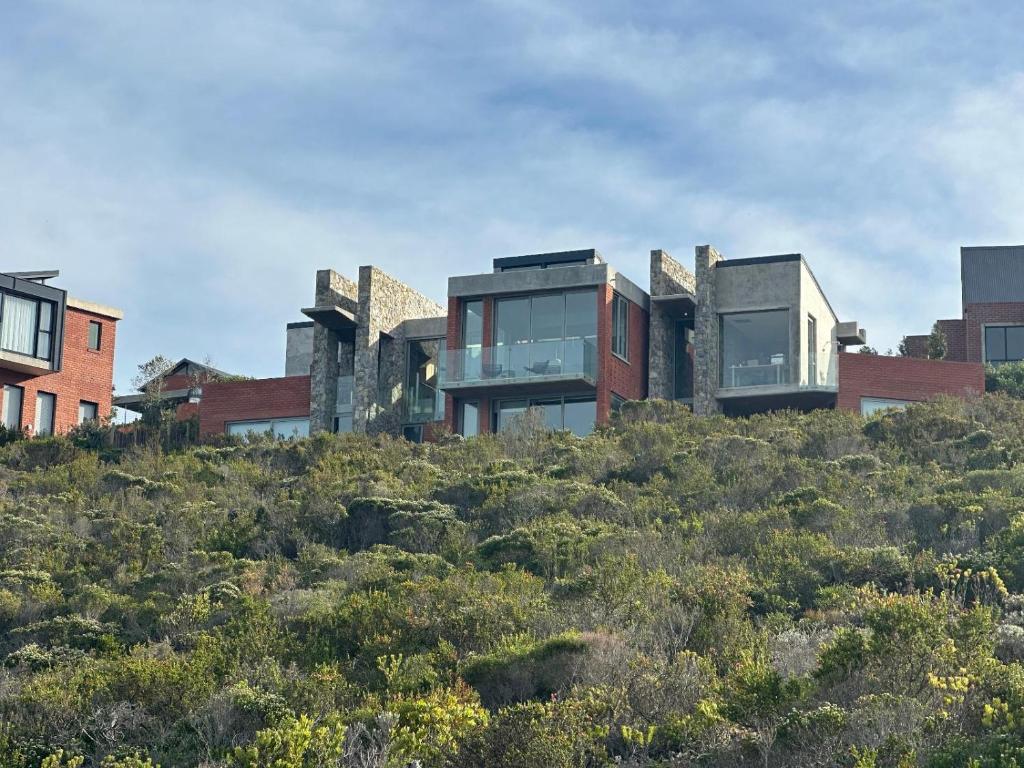 una casa en la cima de una colina con arbustos en RRoar George, en Herolds Bay