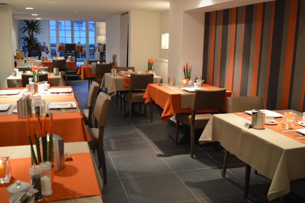 een eetkamer met tafels en stoelen in een restaurant bij Hotel Geeraard in Geraardsbergen