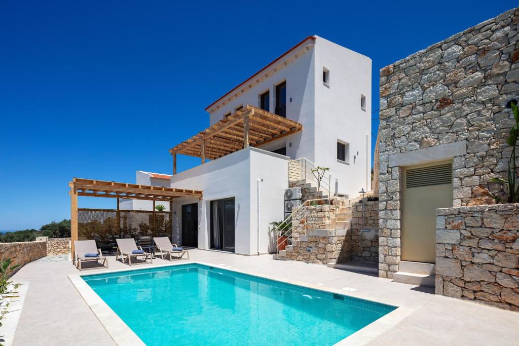 una villa con piscina frente a una casa en Villa Shine, en Roussospítion