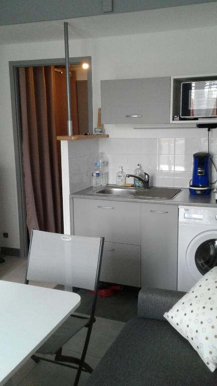 une cuisine avec un évier et une machine à laver dans l'établissement Studio Saint Jean De Monts, à Saint-Jean-de-Monts
