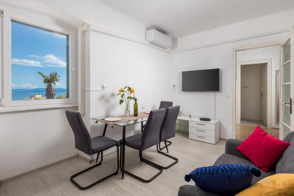 a living room with a table and chairs and a window at Nada apartment in Rijeka