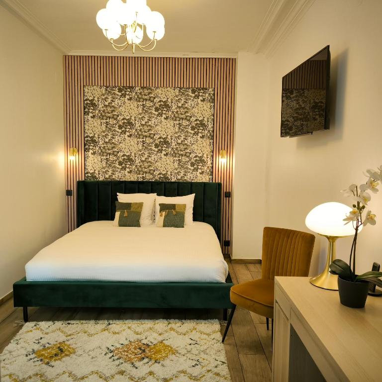 une chambre avec un lit et un lustre dans l'établissement Hotel Le Twelve, à Paris