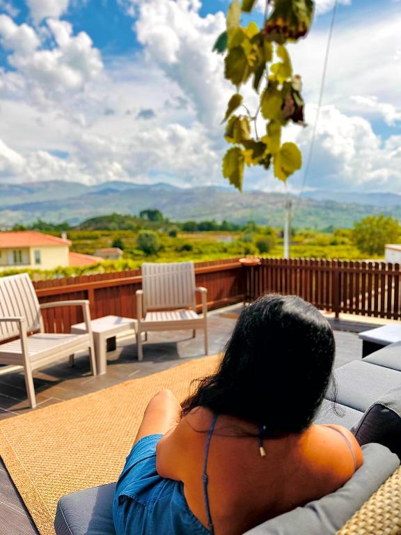 a woman laying on a couch on a patio at Casa da Touça in Arcos de Valdevez