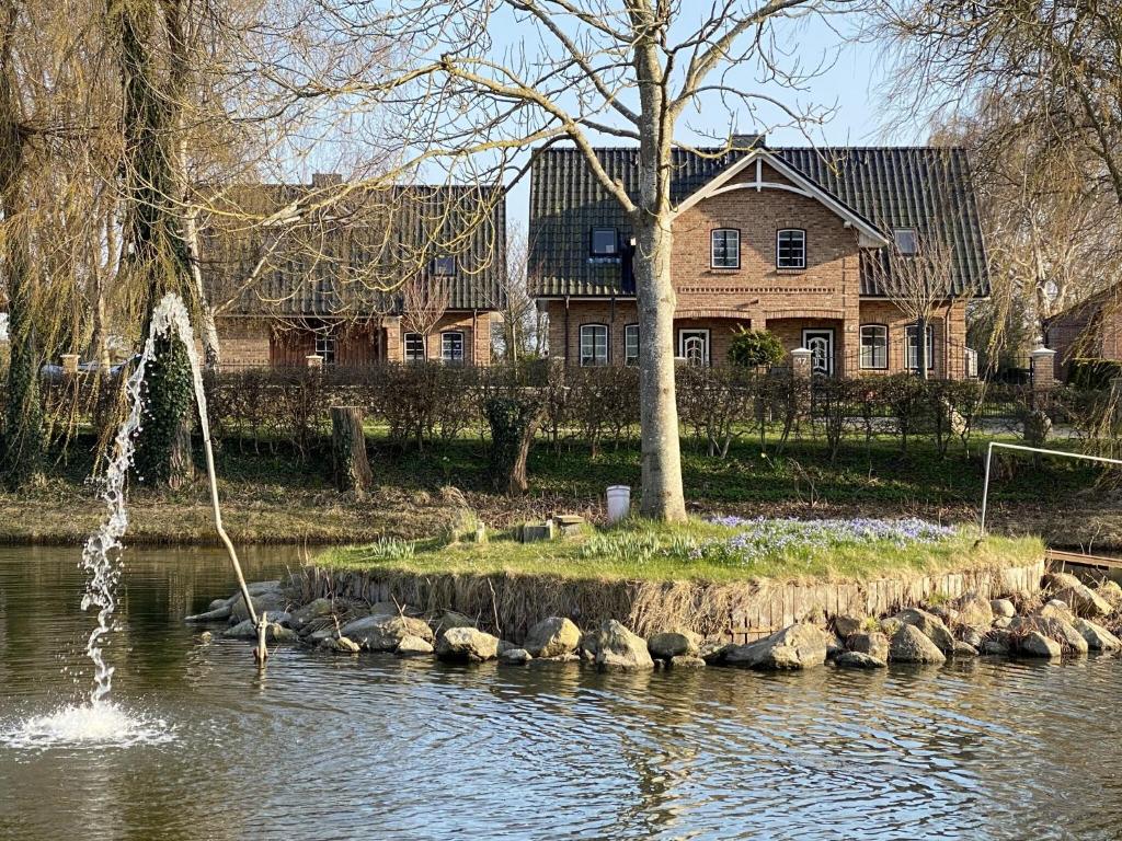 a fountain in the water in front of a house at Haus Am Dorfteich B eingefriedet in Fehmarn