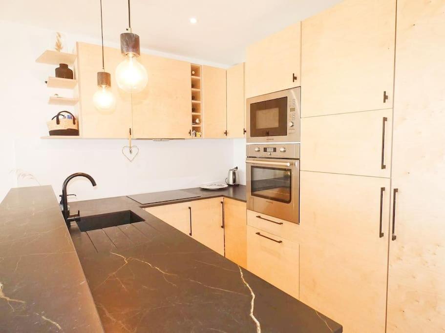 une cuisine avec des armoires en bois et un comptoir dans l'établissement Appartement en première ligne La Grande Motte Climatisé, à La Grande Motte