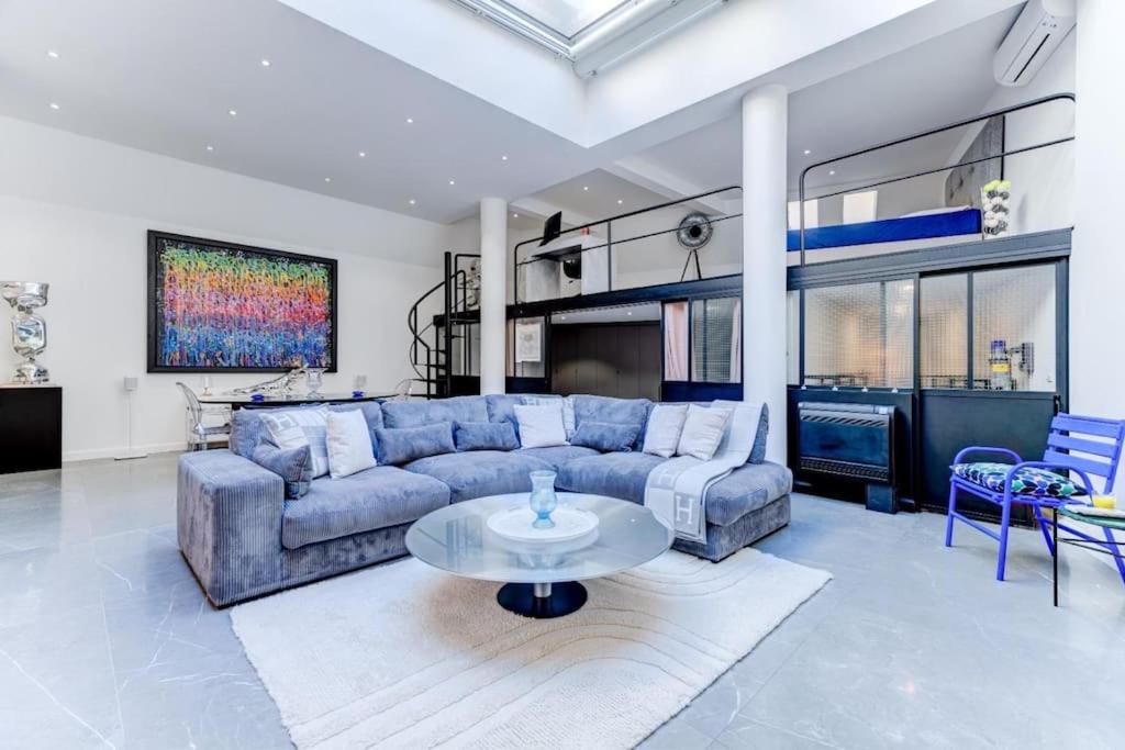 un salon avec un canapé bleu et une table dans l'établissement Magnifique loft au cœur de Nice, à Nice