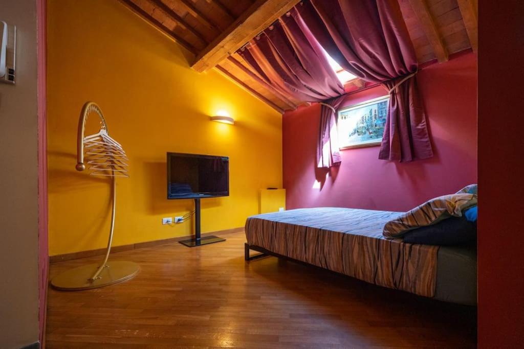 a bedroom with a bed and a window and a television at 22 Home - Parcheggio privato - accogliente - collegamento Sardegna e Corsica in Livorno