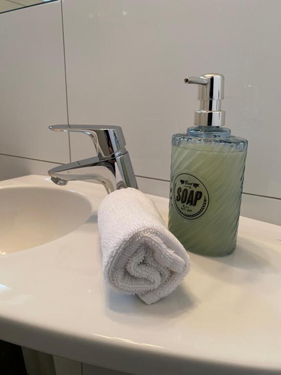 a towel sitting on a sink next to a soap dispenser at Modernes Ferienhaus mit 2 Balkonen, Terrasse und Garten ! in Bochum