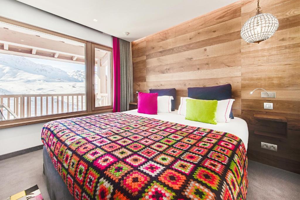 a bedroom with a large bed and a window at Hotel Pashmina Le Refuge in Val Thorens
