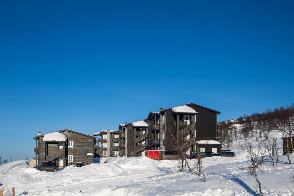 a building in the snow with snow on it at Målselv Fjellandsby Apartments in Bardufoss