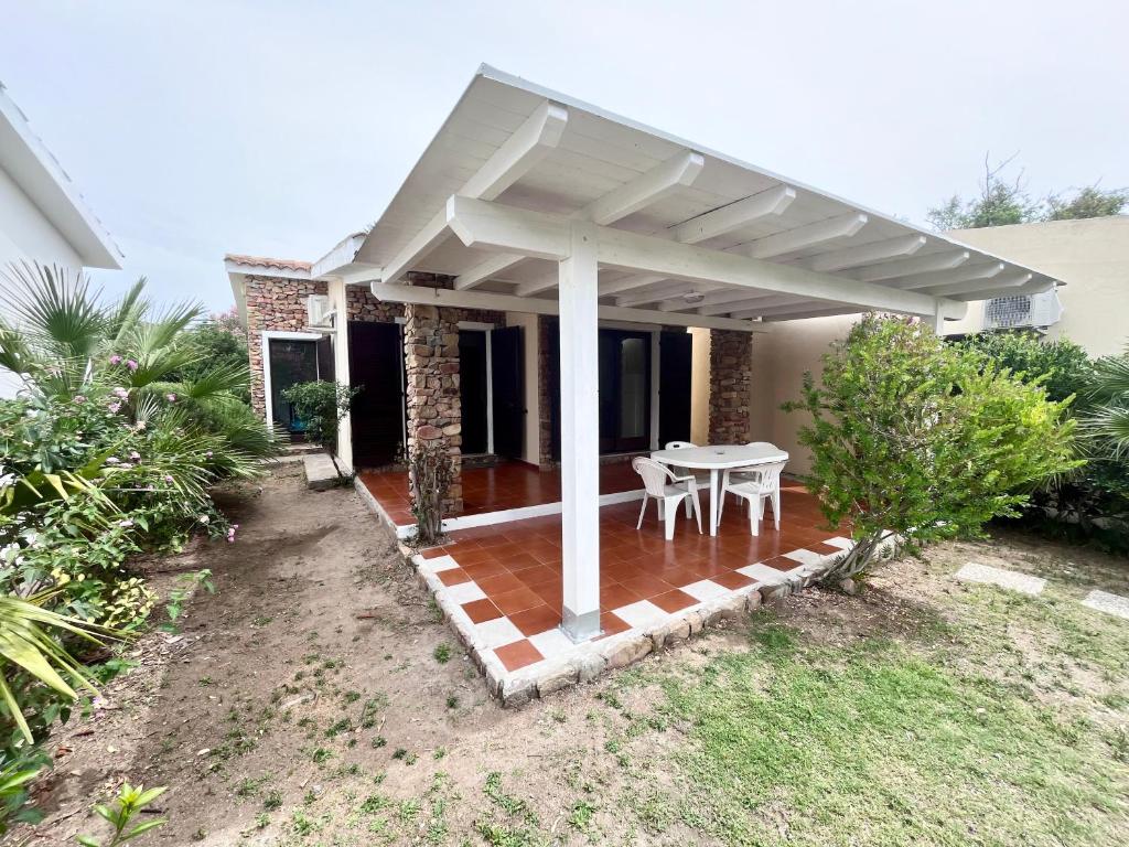 a patio with a white pergola on a house at Villetta Vele 2 By La Via Del Mare Viaggi e Vacanze in Simius