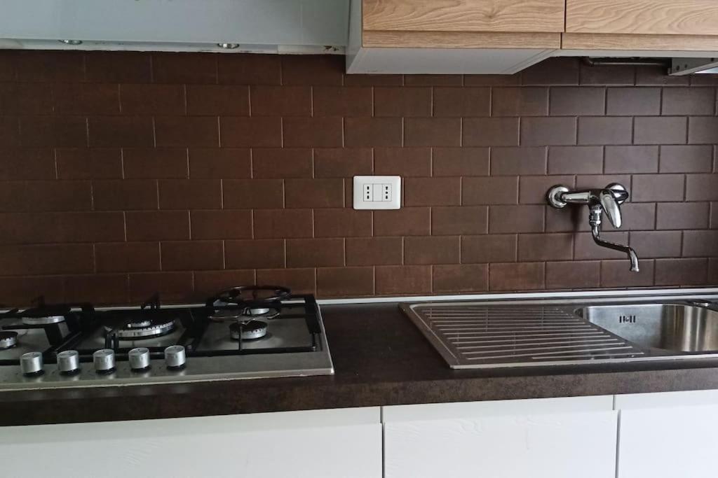 a kitchen counter with a stove and a sink at CASA di ALE Incantevole appartamento con parcheggio gratuito in Verbania