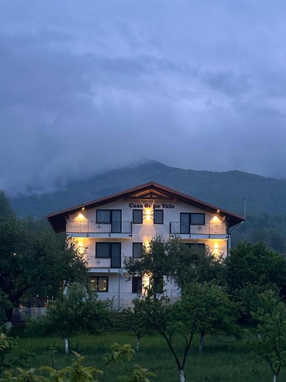 a large white building with lights on it at Pensiunea Casa de pe Vale in Vulcan