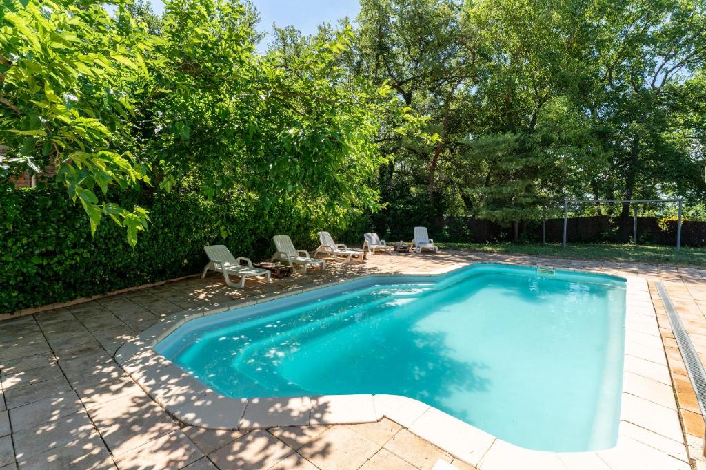une piscine dans une cour avec des chaises autour dans l'établissement Gite Sariette, à Mirabel-aux-Baronnies