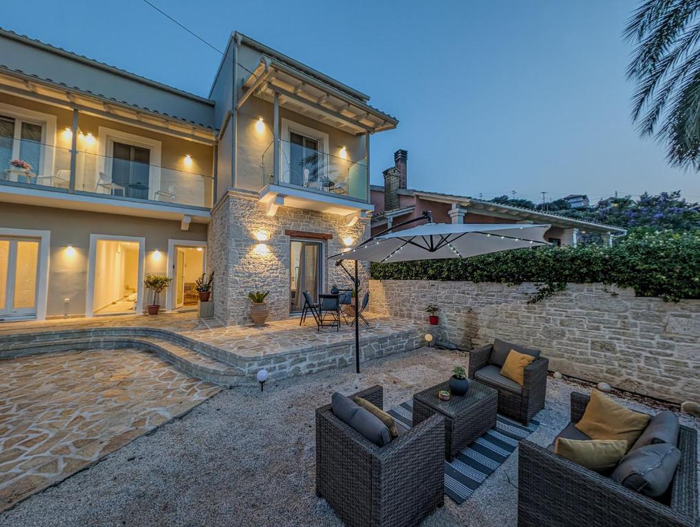 una casa con dos sofás y una sombrilla en Nikoleta Kassiopi Apartment, en Kassiopi