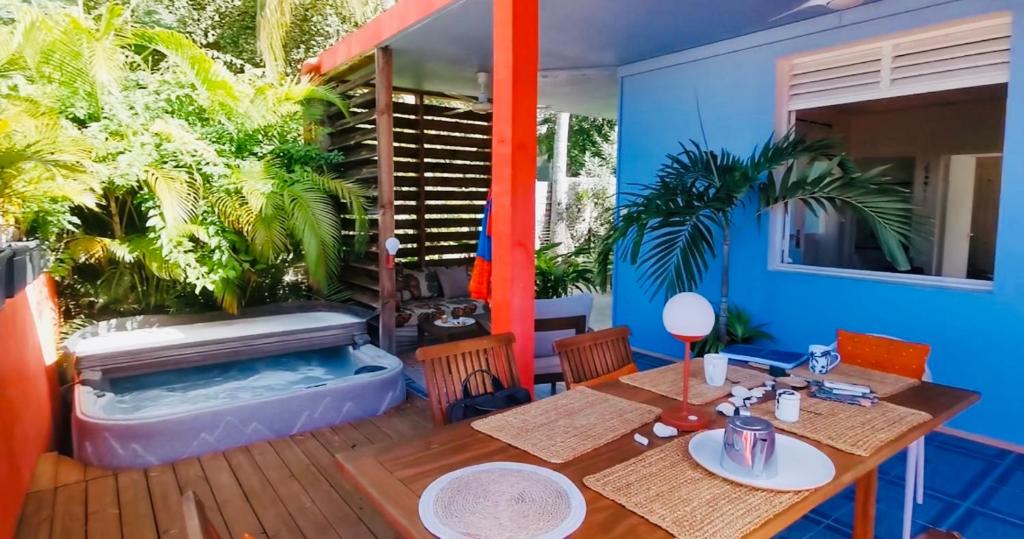 a patio with a table and a hot tub at Villa Victoria in Bouillante