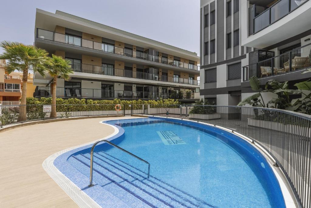 a swimming pool in front of a apartment building at Essential by Charlie in Jávea