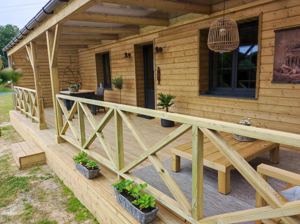 a wooden deck of a cabin with potted plants at Gîte Ar Friz Vihan in Briec
