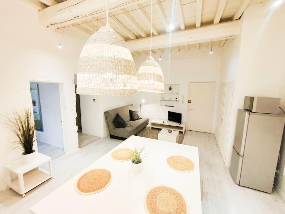 - un salon blanc avec une table et un réfrigérateur dans l'établissement Appartement Le Flocon 2 chambres Maison Carrée Centre historique, à Nîmes