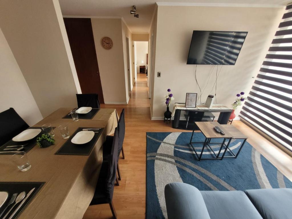 a living room with a table and chairs and a television at Fantástico Departamento Central-2Hab-2Baños in Antofagasta