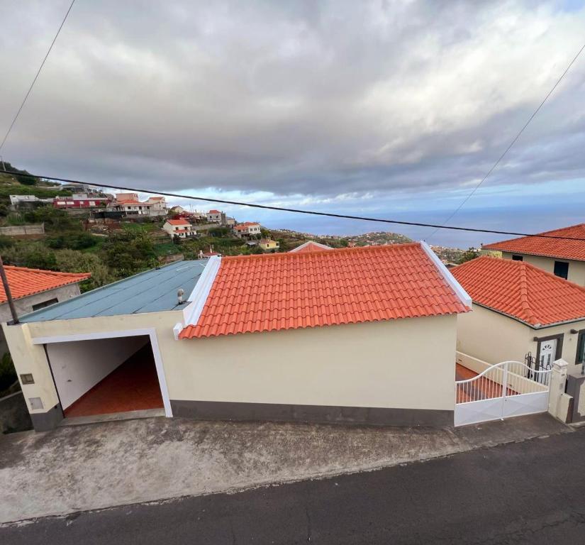 una casa blanca con un techo naranja en Villa Abreu, en Ponta do Sol