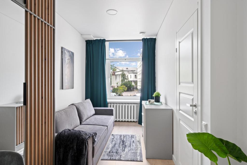 Una sala de estar con un sofá y una ventana. en Central Cozy 1Bedroom Apartment with Sofa Bed - Sleeps 4, en Vilna
