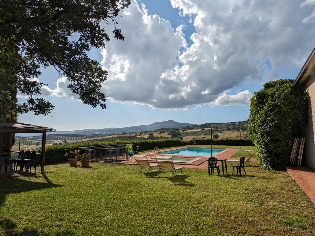 a yard with chairs and a pool with a view at Il Giovannello in Roccastrada