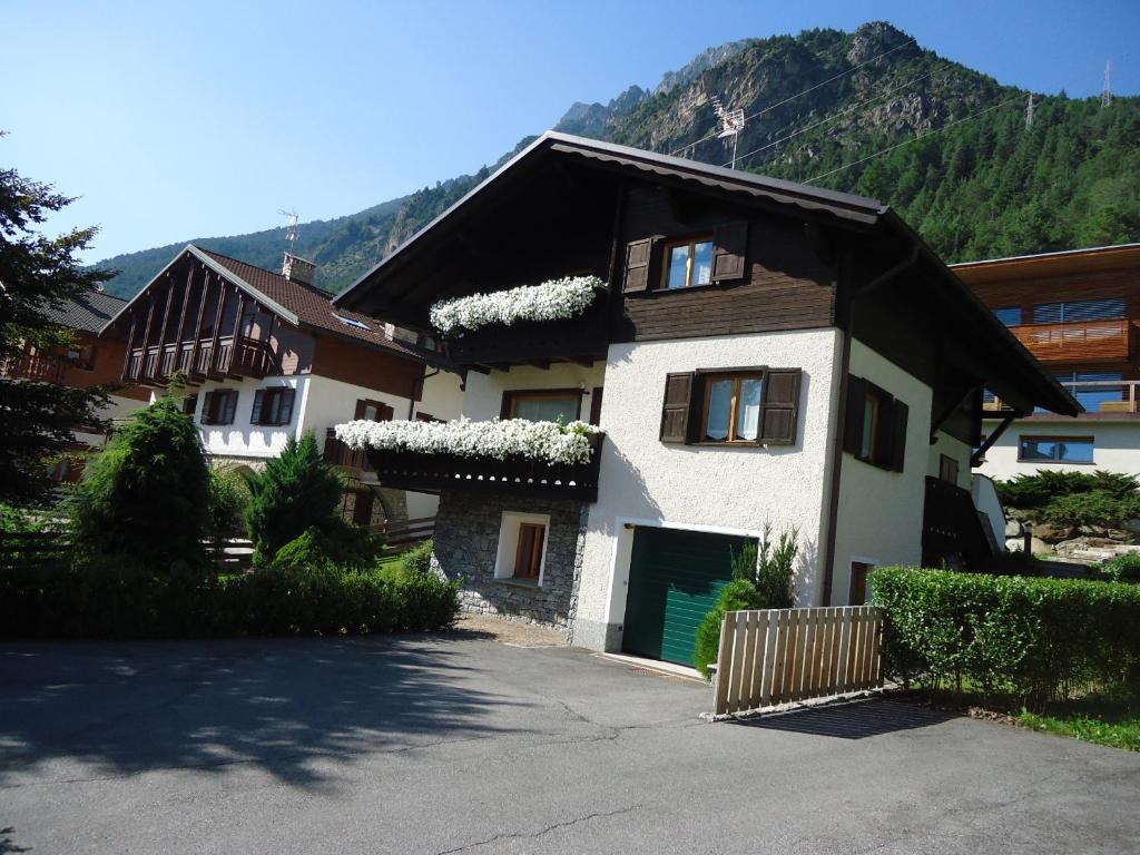 ein Haus mit einer grünen Tür und einem Berg in der Unterkunft Casa Martinelli - Trameri in Bormio