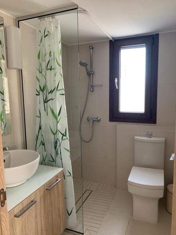 a bathroom with a shower and a sink and a toilet at Modern 1 bedroom sea view beach apartment in Limassol
