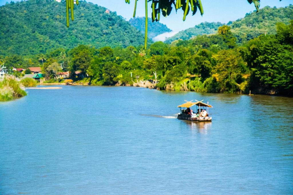 un bateau avec des gens sur une rivière dans l'établissement Areeya Phuree Resort Thaton, à Mae Ai