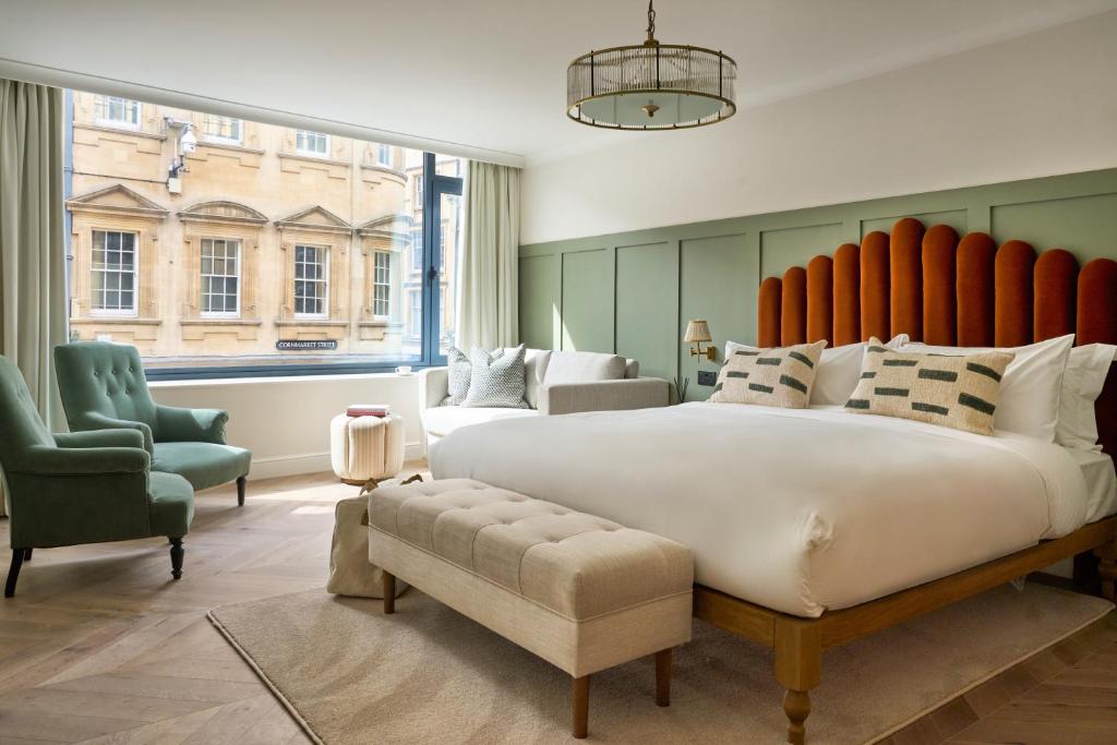a large bedroom with a large bed and two chairs at The Store in Oxford