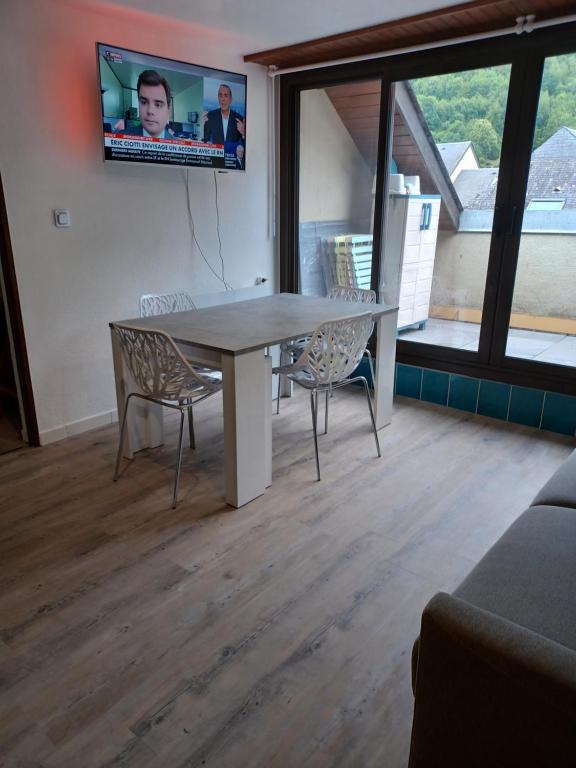 a dining room table with two chairs and a tv on the wall at Aurette in Saint-Lary-Soulan
