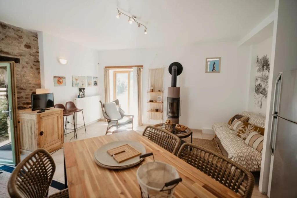 une cuisine et un salon avec une table et des chaises dans l'établissement Gîte de la Rivière, à Pluvigner