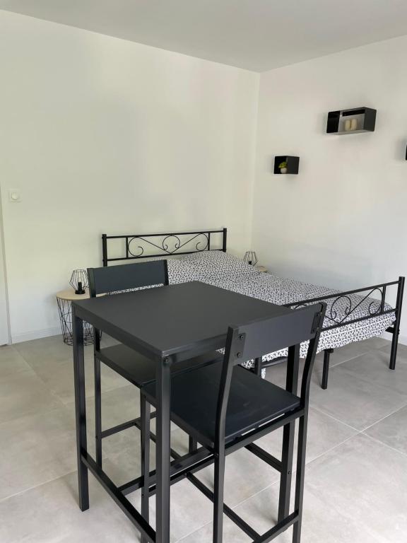 - une table et des chaises noires dans une chambre avec un lit dans l'établissement Chambre indépendante Proche du Futuroscope, à Poitiers