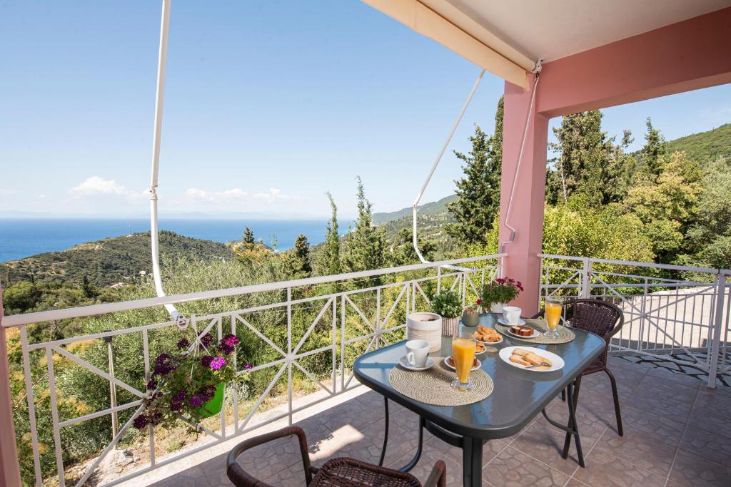 a table and chairs on a balcony with a view of the ocean at Agnantio in Agios Nikitas