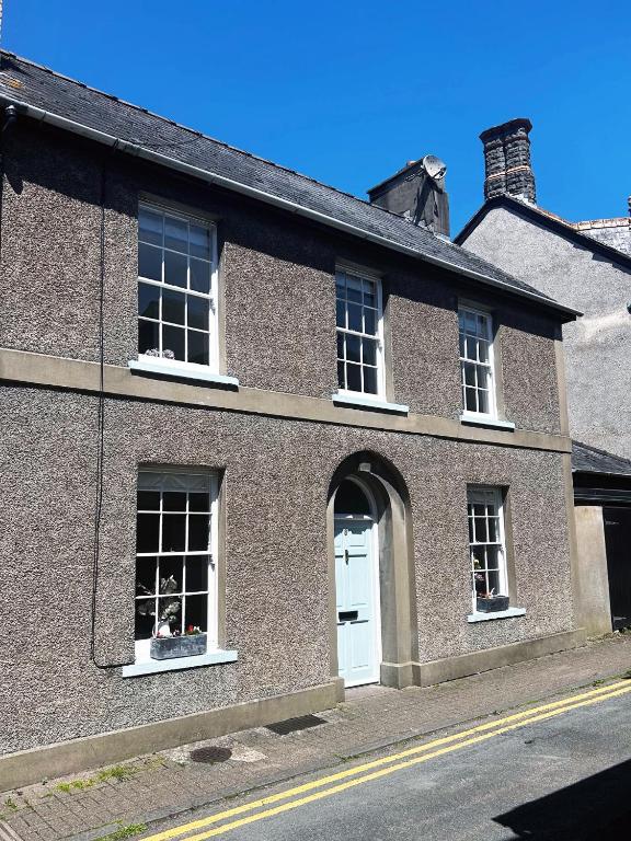a brick building with a white door and windows at 2 bed period cottage sleeps 4 in central Crickhowell in Crickhowell