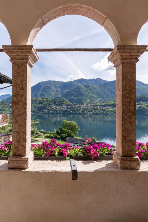a view of a lake from a window with flowers at Appartamenti VERDE ACQUA in Pergine Valsugana