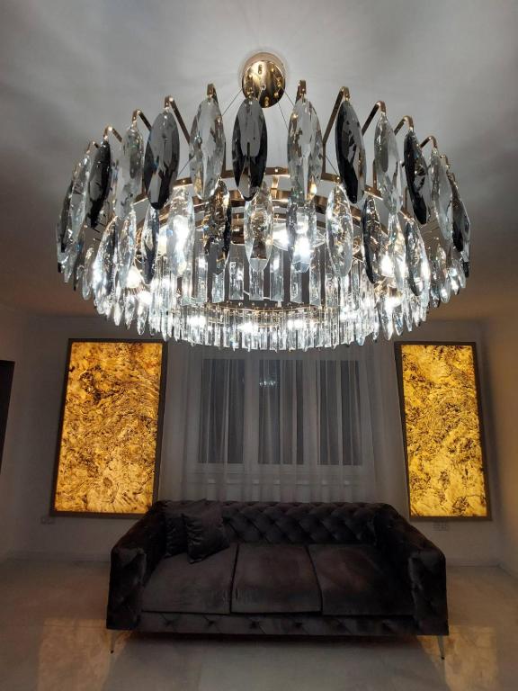 a chandelier in a living room with a couch at Berenát Villa in Nyíregyháza