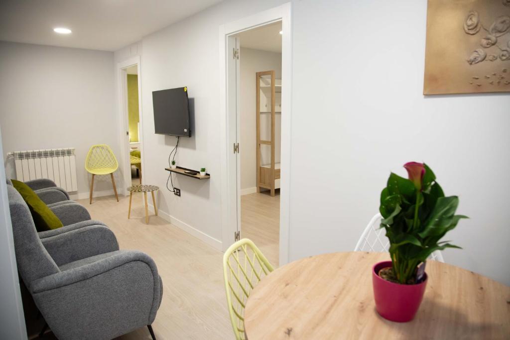 a living room with a table and chairs and a tv at Pregonero Urban Suites - Verde in Soria