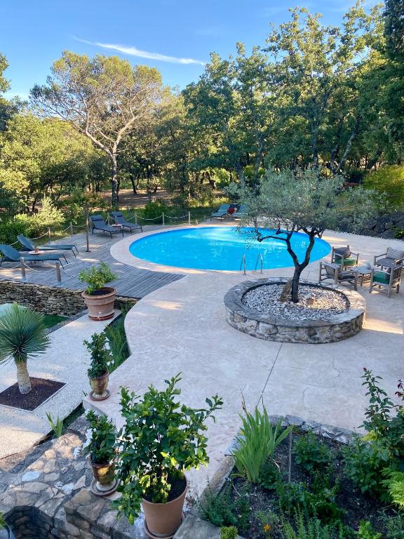 une piscine avec une table, des chaises et des arbres dans l'établissement Maison Terre de Lune, à Mondragon