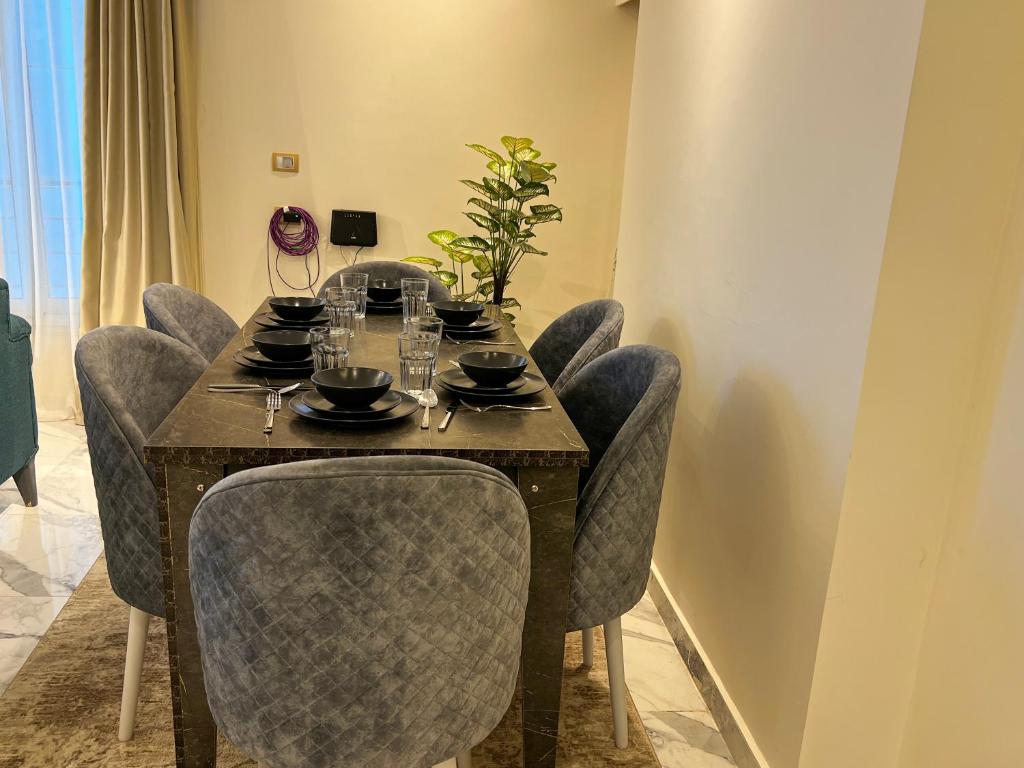 a dining room table with chairs and a table with glasses at Skyline Premium Properties in Alexandria